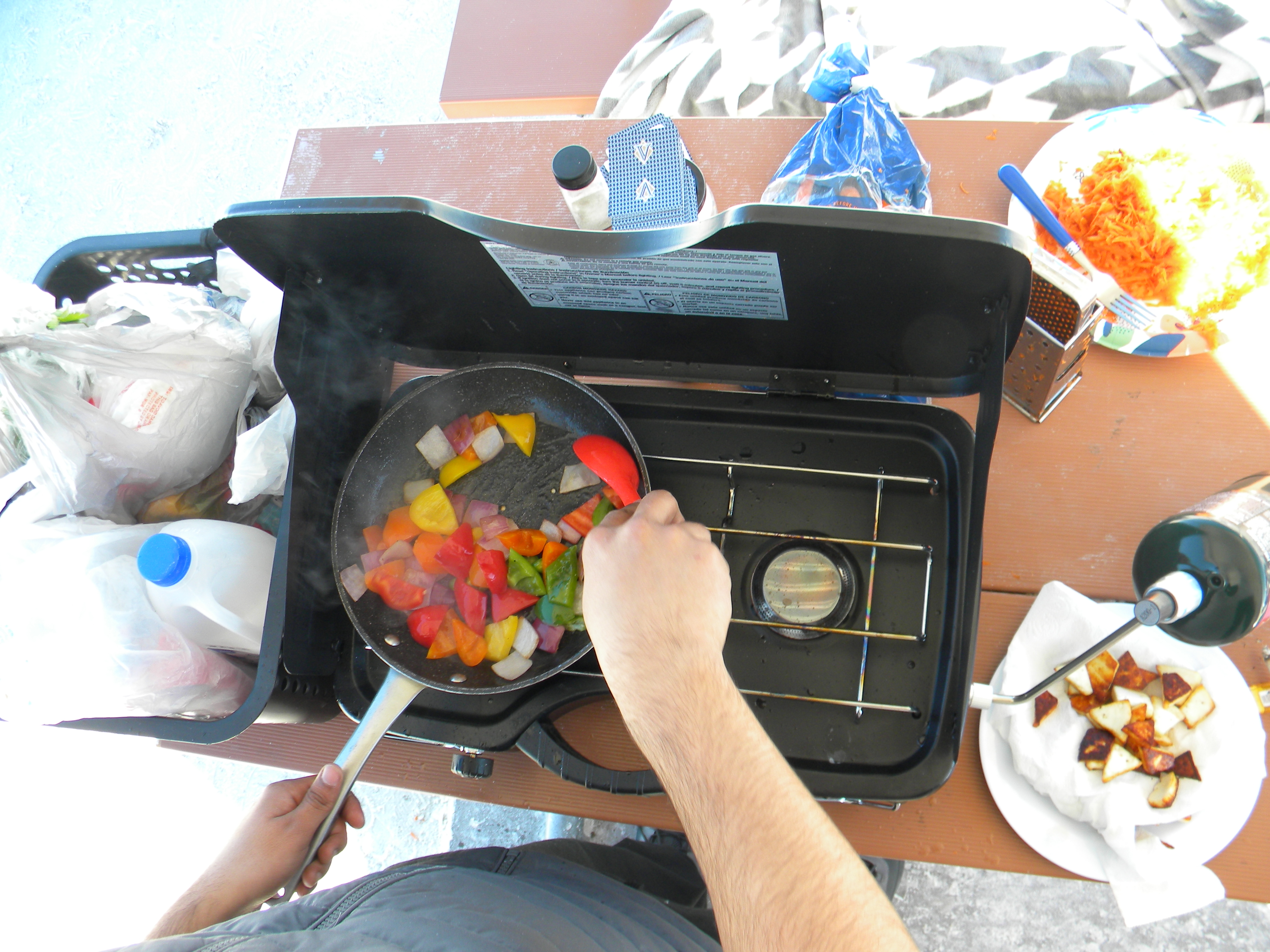 overhead photo of vegitables in a pan over a gas stove